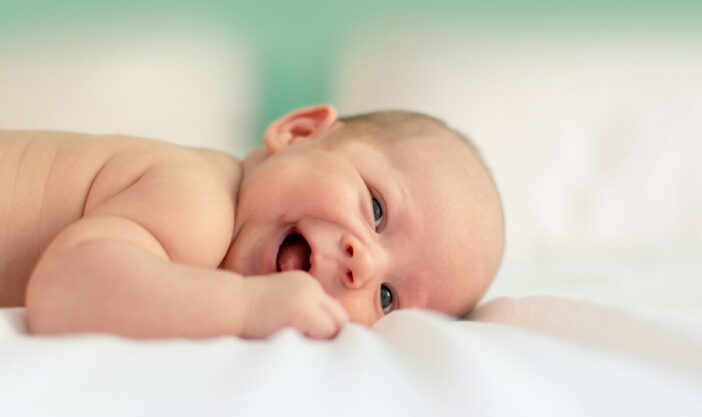 baby lying on fabric cloth