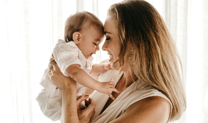 smiling woman carrying baby